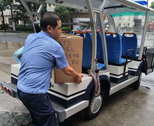 夏养行用巡逻车运送行李到校门口